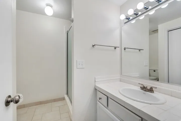 Full bathroom with vanity and a shower stall