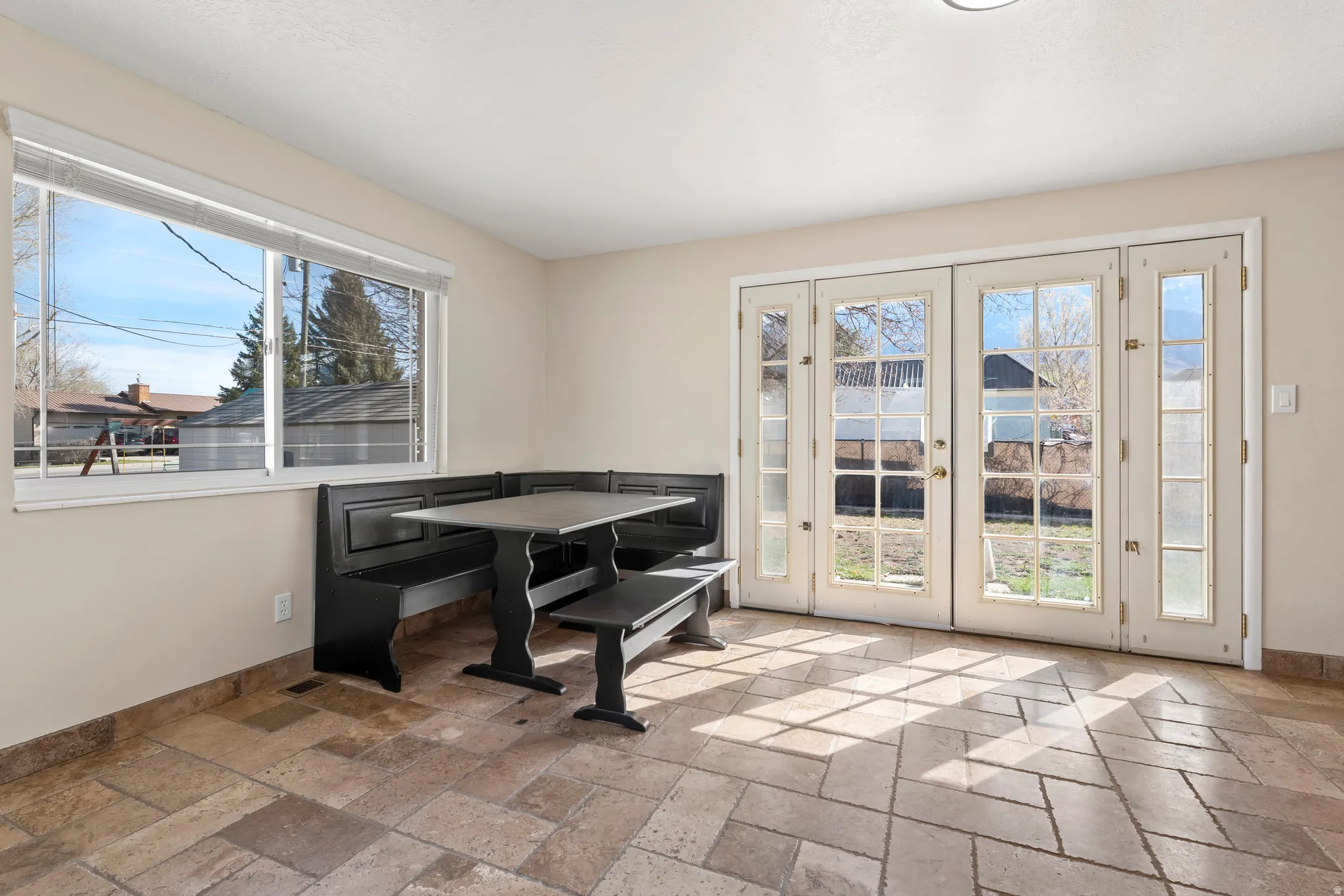 Dining area featuring stone tile flooring and french doors
