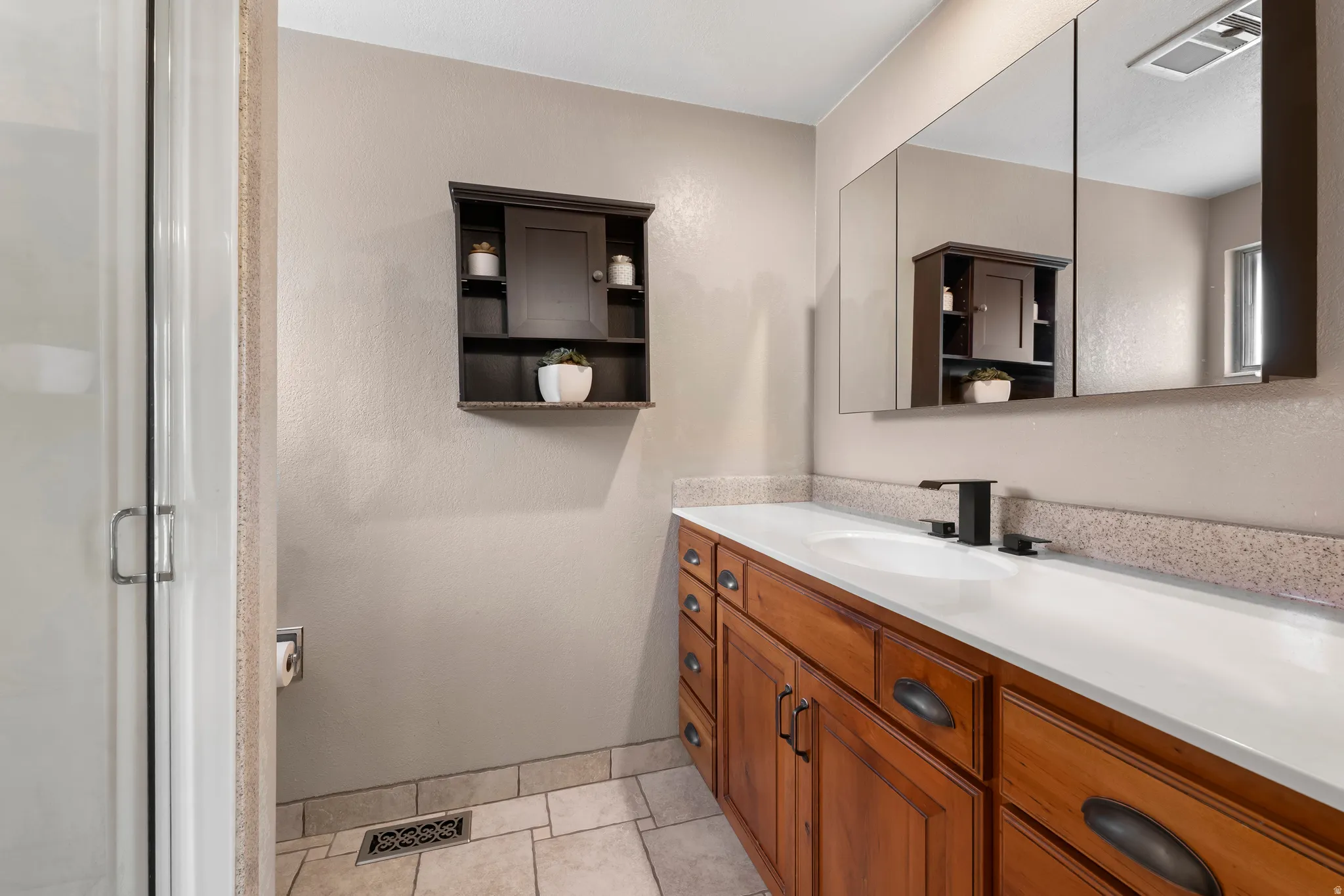Bathroom with vanity, a shower stall, and light tile patterned flooring