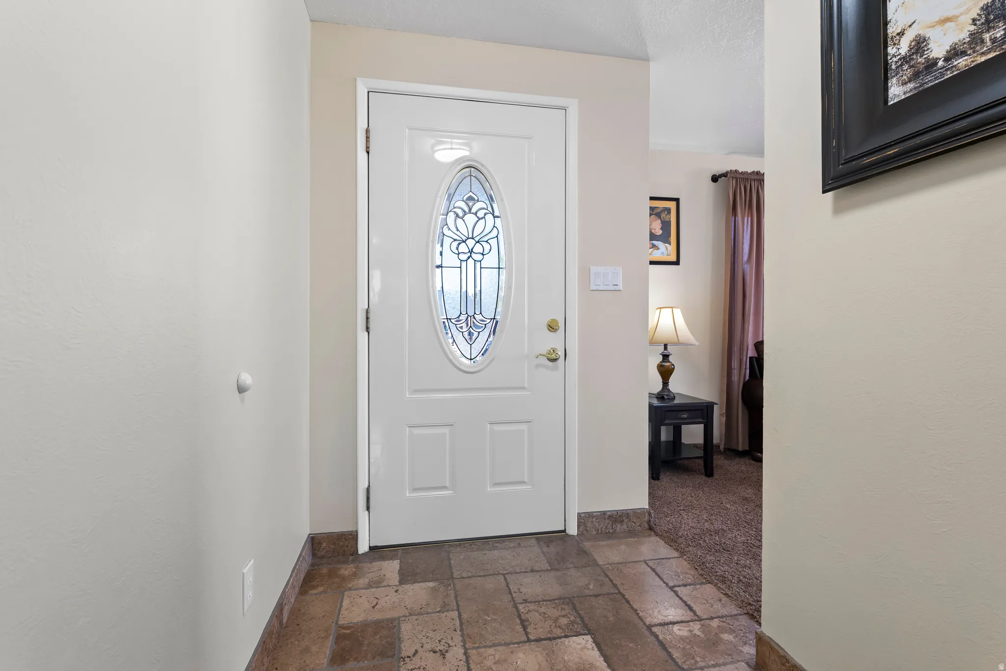 Foyer entrance featuring stone tile flooring and baseboards