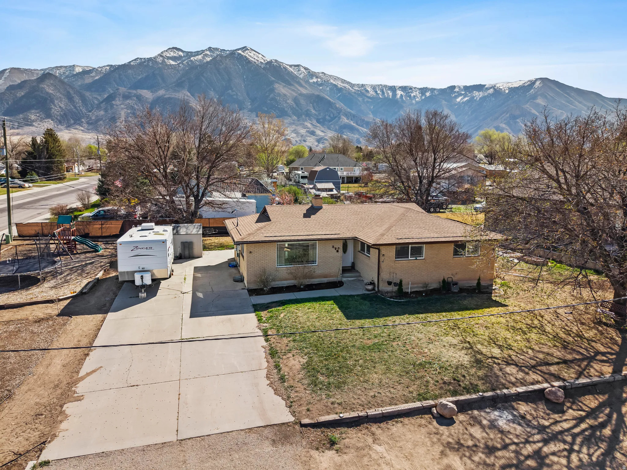 View of front of property featuring brick siding, a mountain view, and driveway