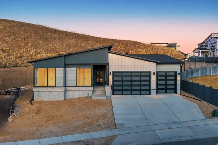 Contemporary home with a garage, concrete driveway, and board and batten siding