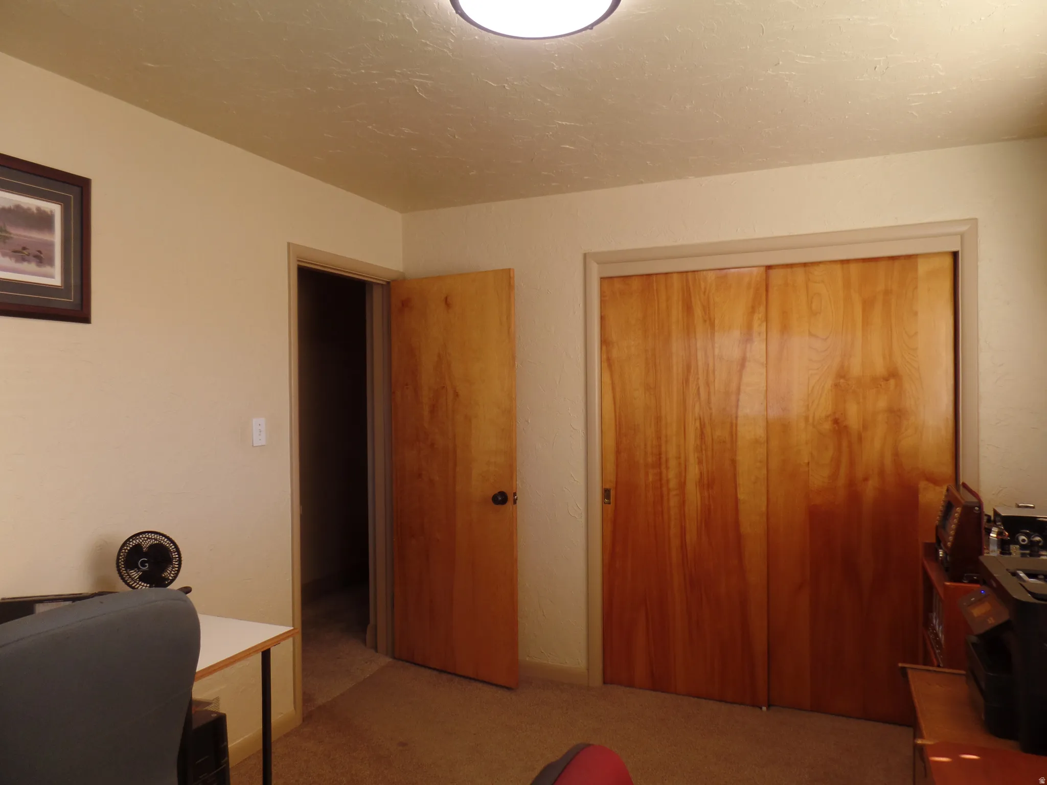 Office area featuring light carpet and a textured ceiling
