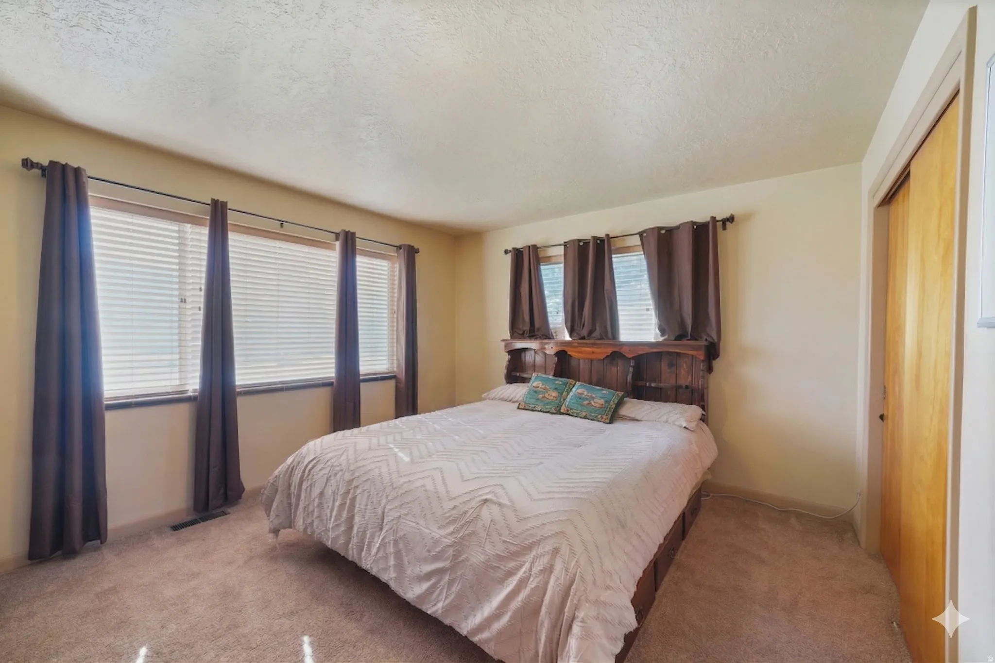 Carpeted bedroom featuring a closet and a textured ceiling