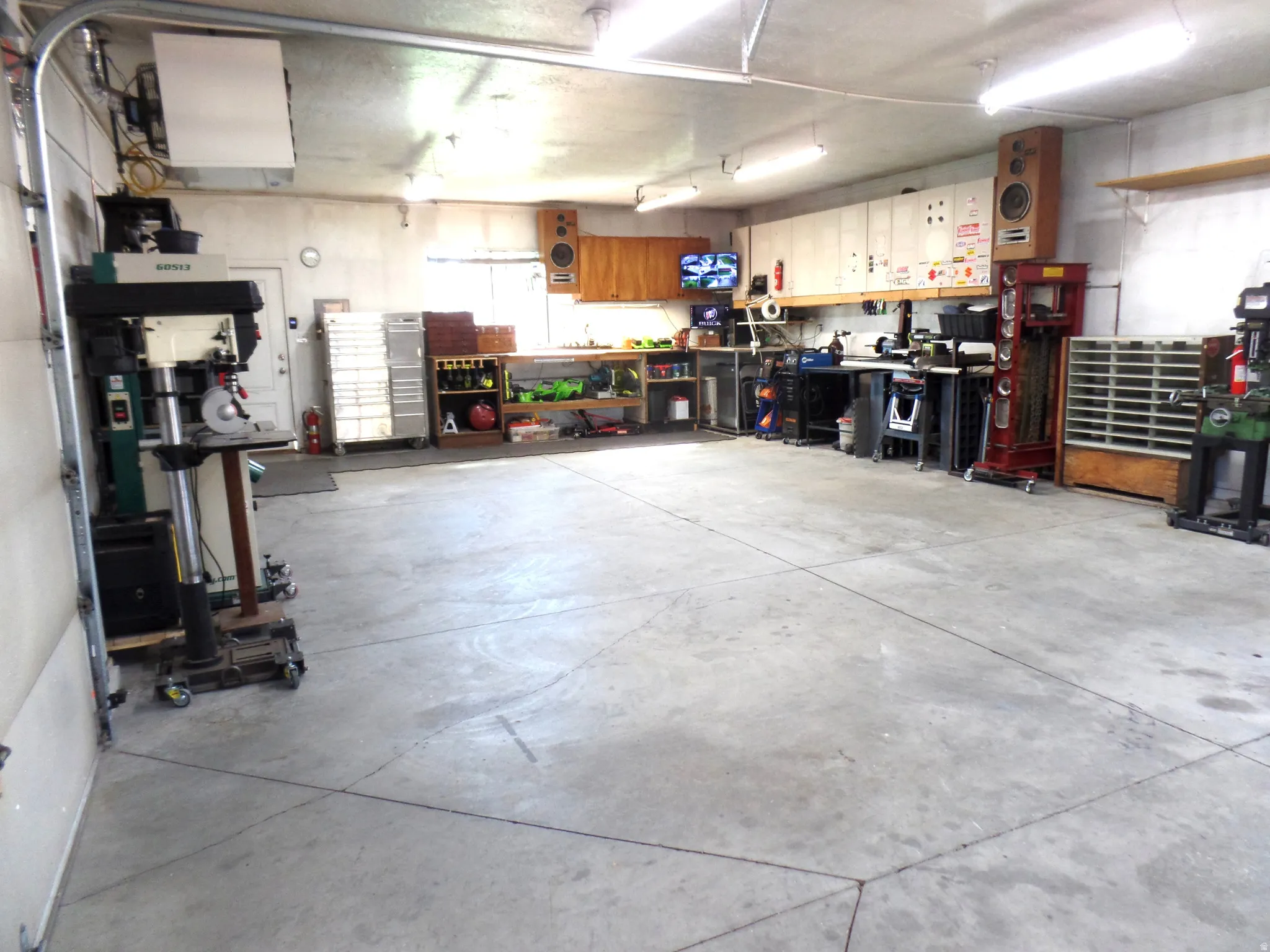 LARGE Garage featuring a workshop area, a heating unit, a 220V outlet, plumbed for air, and cabinets