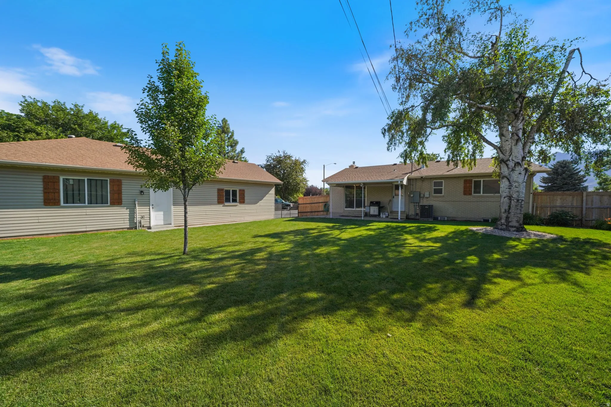 Back of property with a fenced backyard and a patio