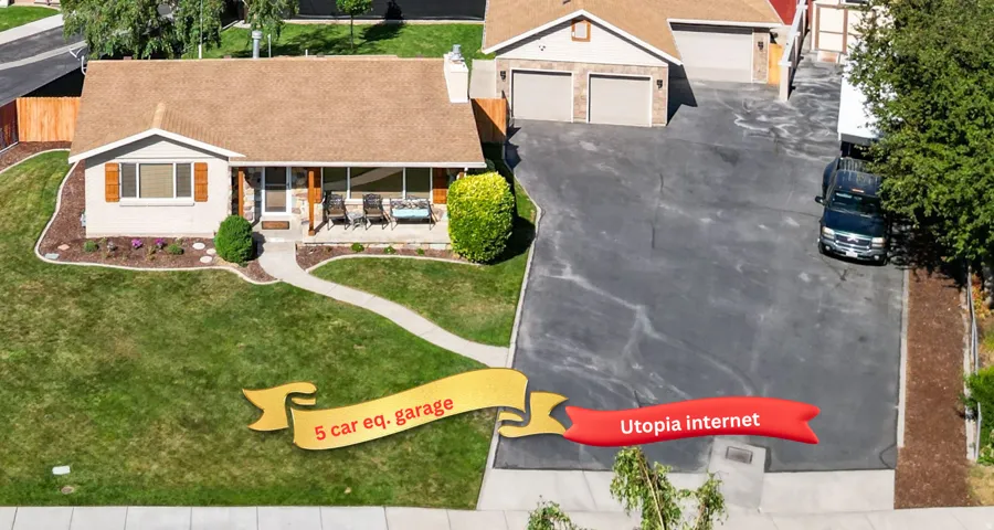 Single-story residence featuring a broad front lawn, mature landscaping, and an extended driveway