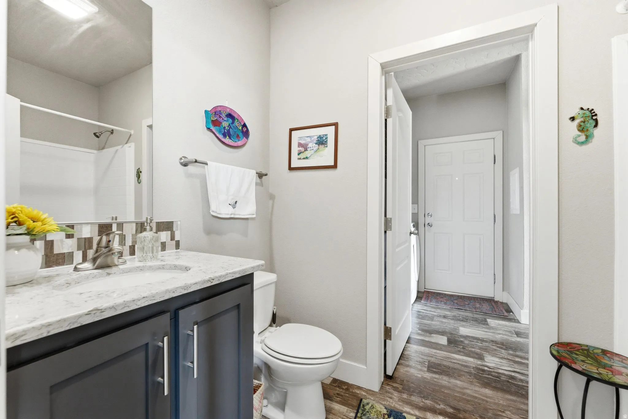 Bathroom with vanity, dark wood-style floors, and a shower