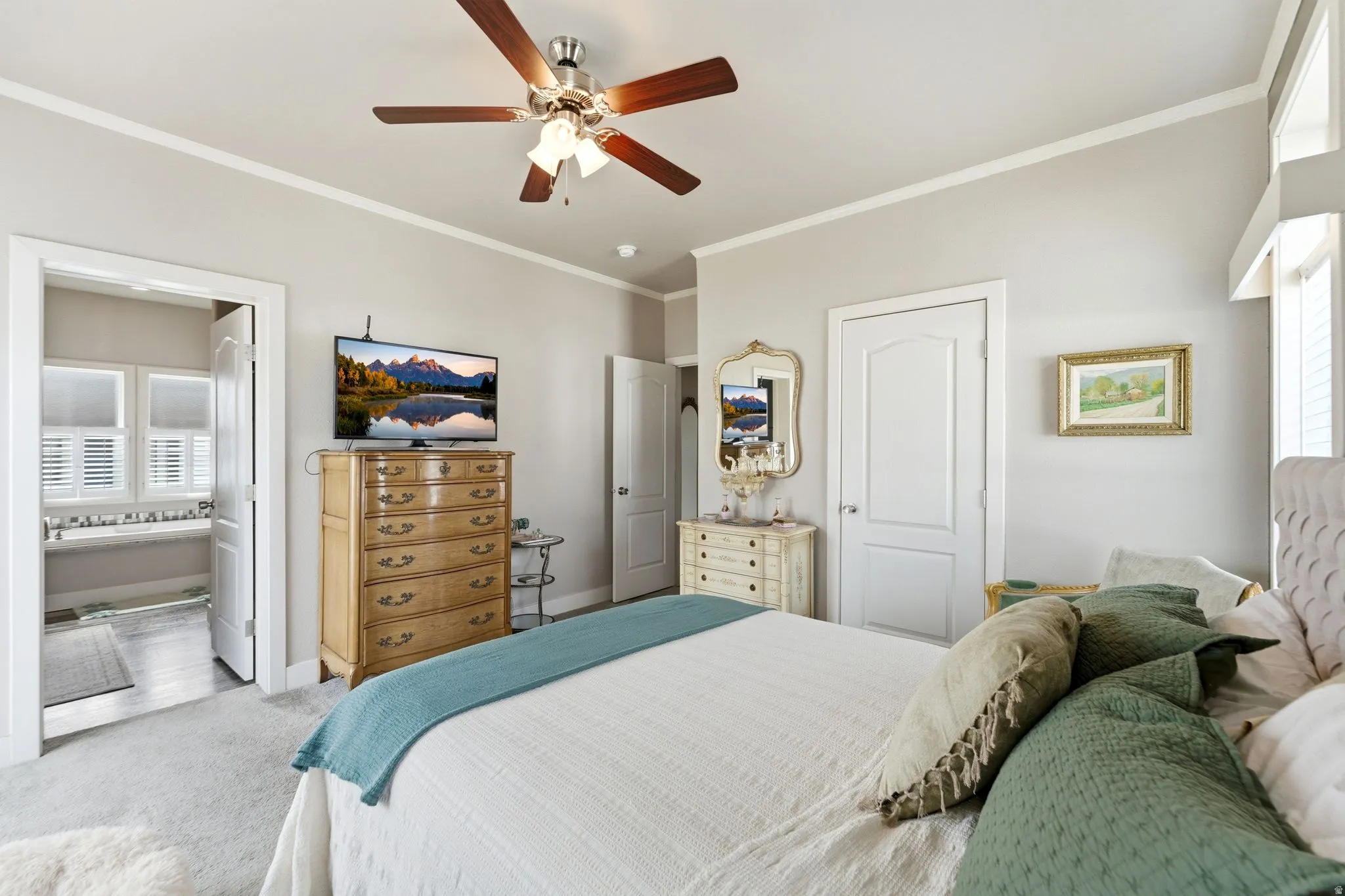 Bedroom with carpet, ornamental molding, a ceiling fan, and a closet