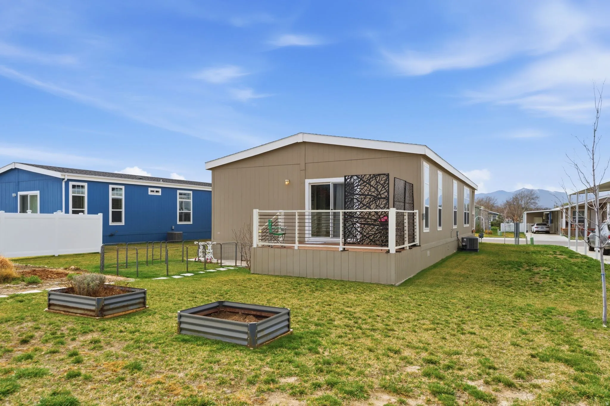 Rear view of property featuring a vegetable garden and a deck with mountain view