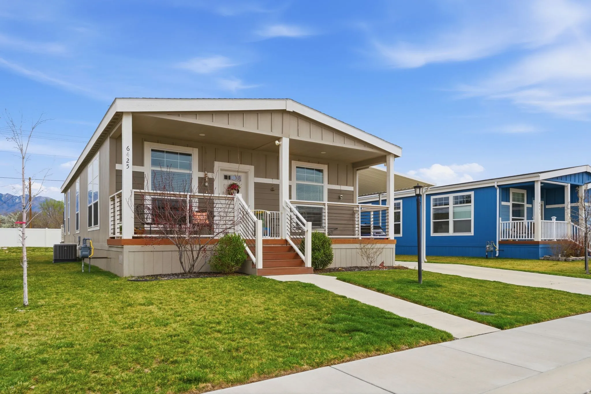Manufactured / mobile home featuring a porch, a front yard, and board and batten siding