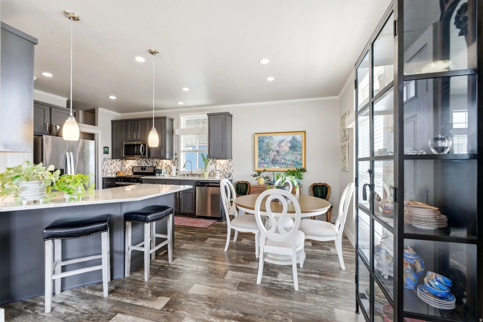 Kitchen featuring light stone counters, a breakfast bar, stainless steel appliances, crown molding, and tasteful backsplash