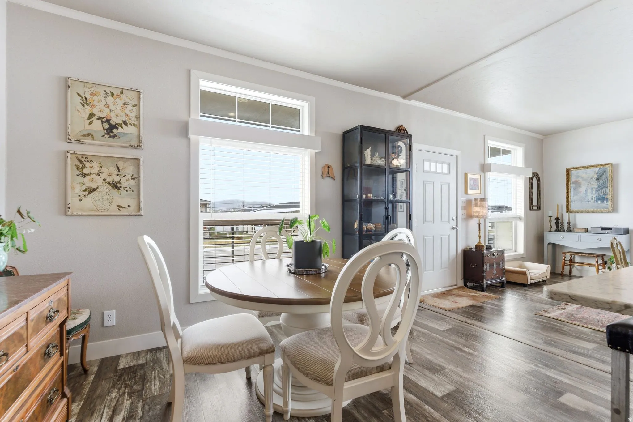 Dining room with ornamental molding and dark wood-type flooring