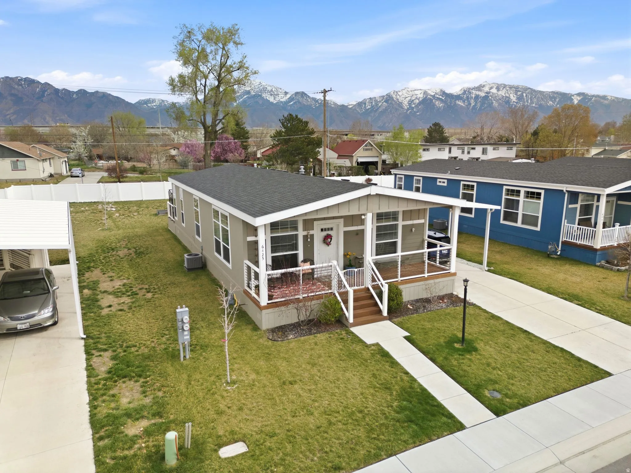 View of front of home featuring a front yard, driveway, a mountain view, roof with shingles, and a residential view