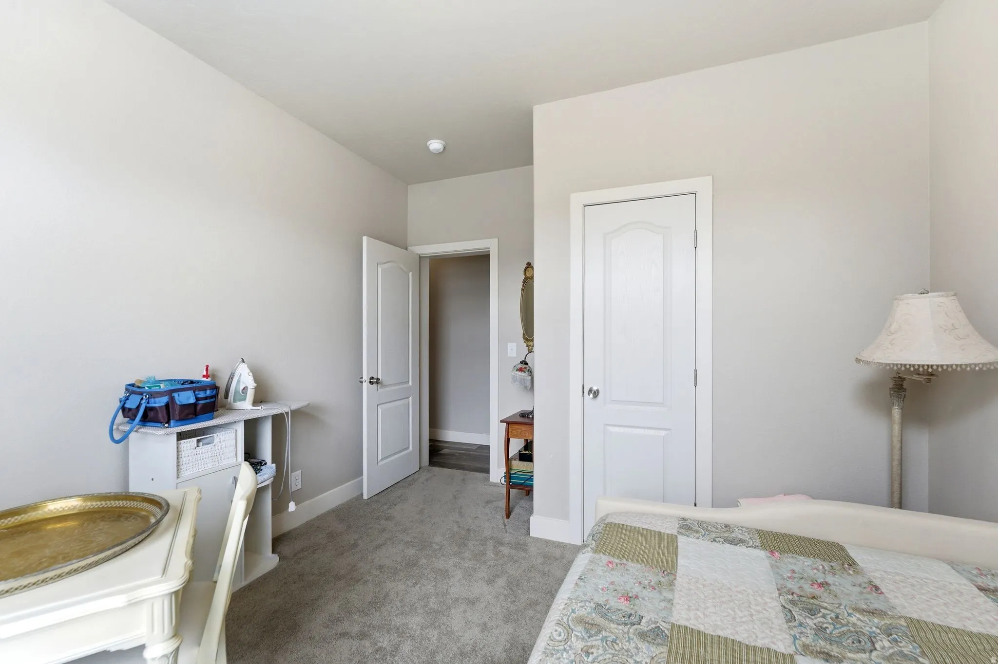Bedroom featuring light carpet and baseboards