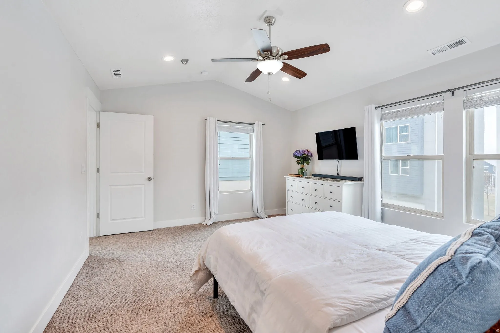 Primary Suite featuring light colored carpet, ceiling fan, and recessed lighting