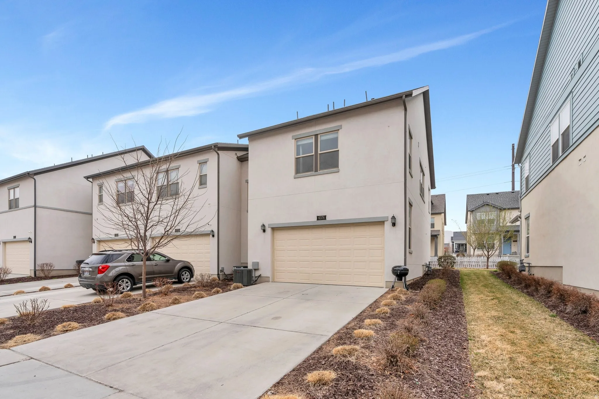 View of front of home featuring an attached garage, stucco siding, and concrete driveway