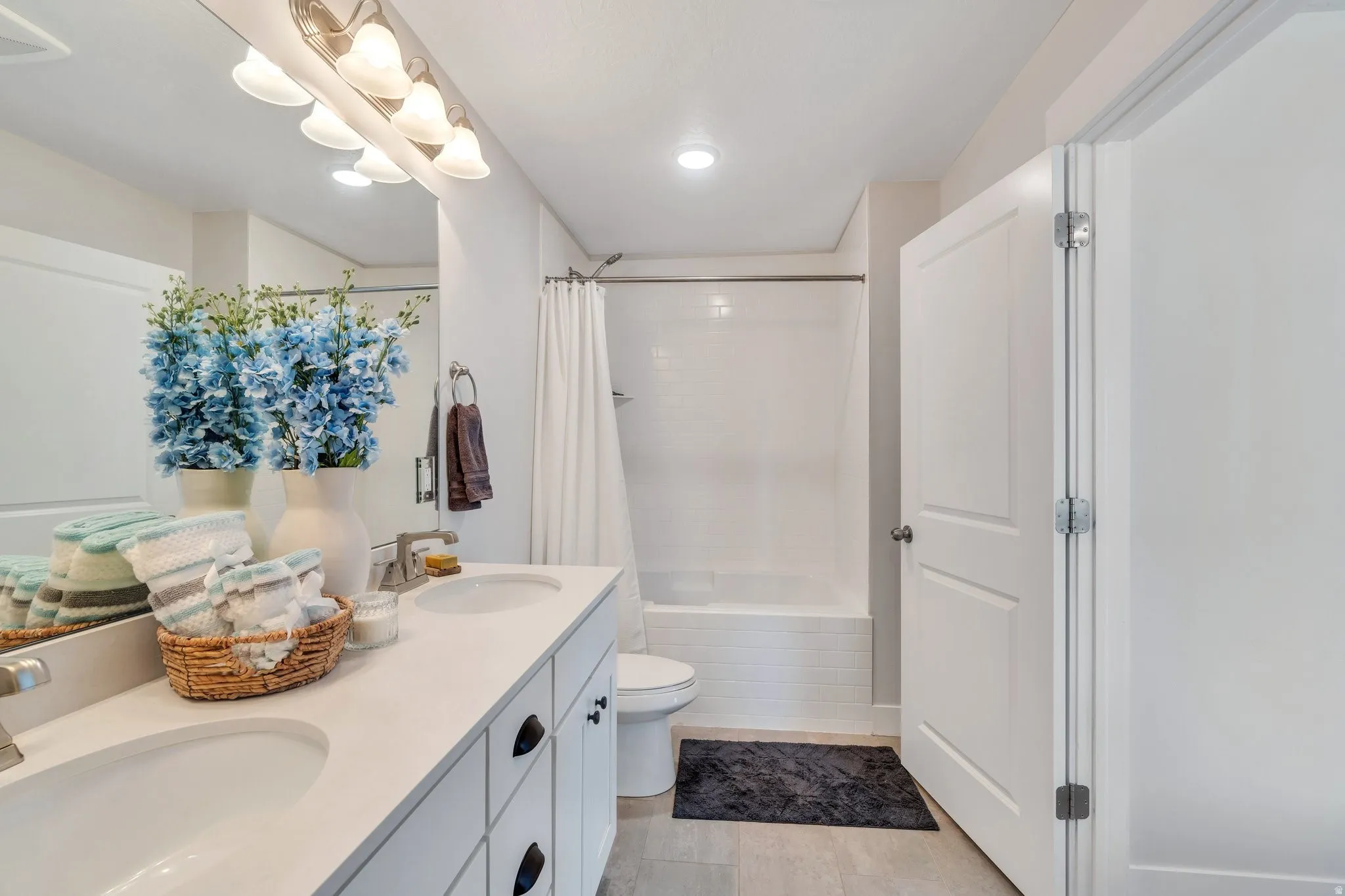 Ensuite bathroom featuring chic lighting, a spacious double vanity sink, and modern finishes.