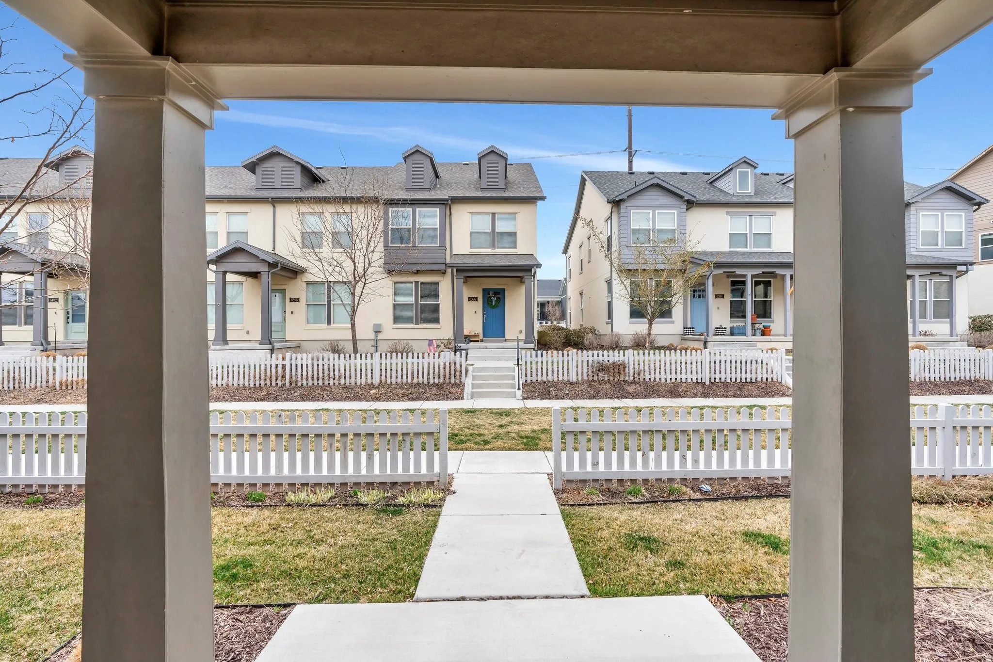 View of front of house featuring covered porch, a fenced front yard, and a gate