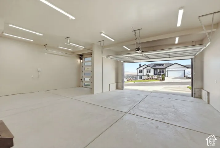 Expansive garage w/tall ceilings, EV Charger, garage sink and storage.