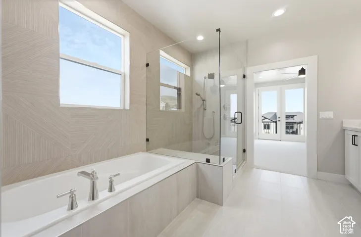 Light and bright primary featuring tile floors and floor to ceiling tile along the tub/shower wall.