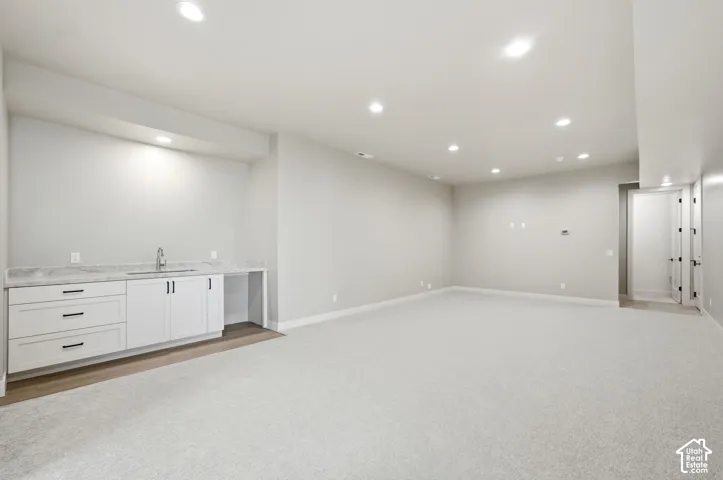 Large family room in basement with kitchenette.
