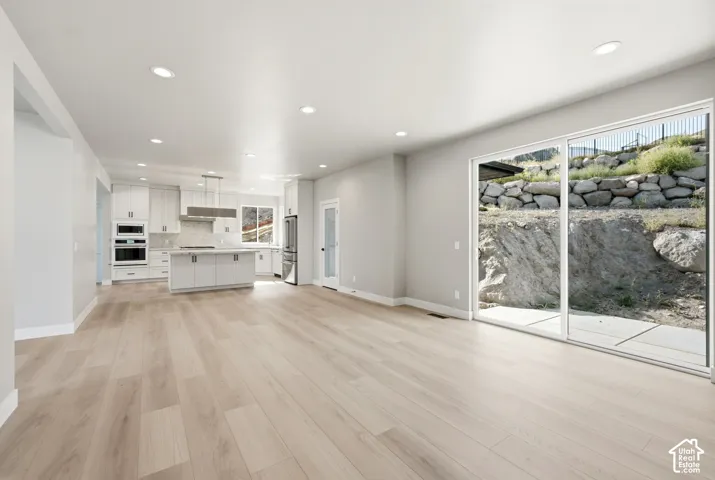 Open concept living area featuring wood-finish flooring, recessed lighting, and a modern kitchen