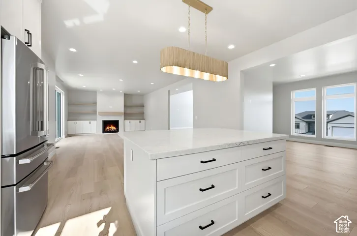 Central kitchen island with a stone countertop and white cabinetry