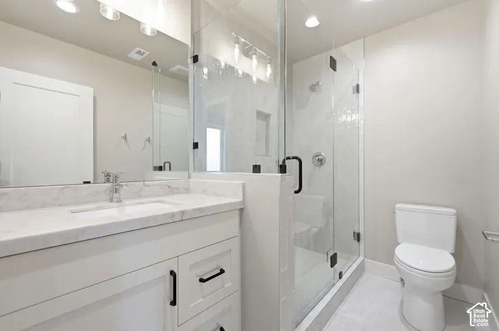 White vanity with a single basin sink and stone countertop