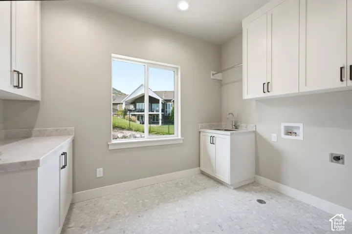 Large laundry room with plenty of cabinetry and space to move around.  You will enjoy the large window that brings in a lot of natural light.