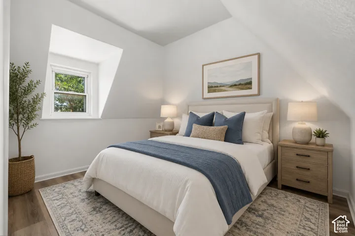 Bright bedroom featuring a dormer window, wood-finish flooring, and sloped ceilings