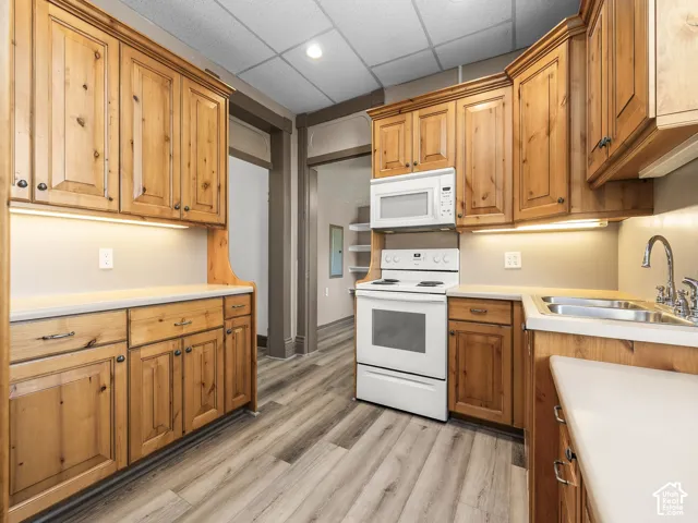 Kitchen featuring knotty wood cabinetry, light-toned countertops, and wood-finish flooring