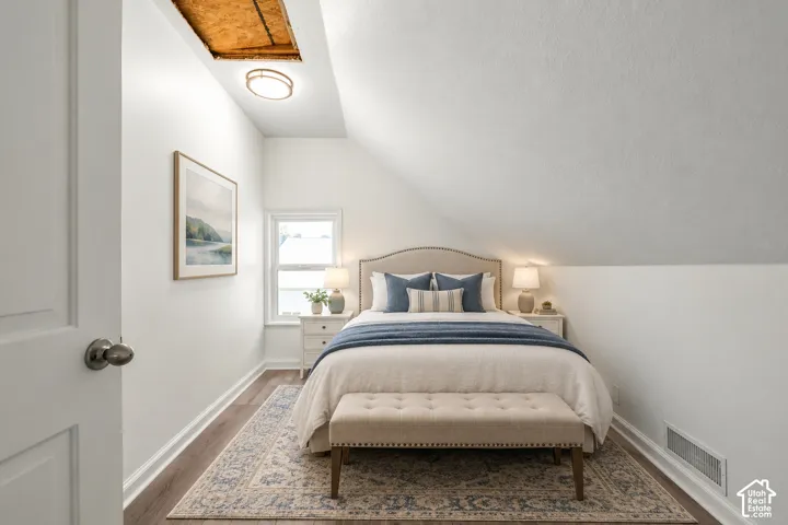 Bedroom featuring wood-finish flooring, a double-hung window, and a ceiling-mounted light fixture