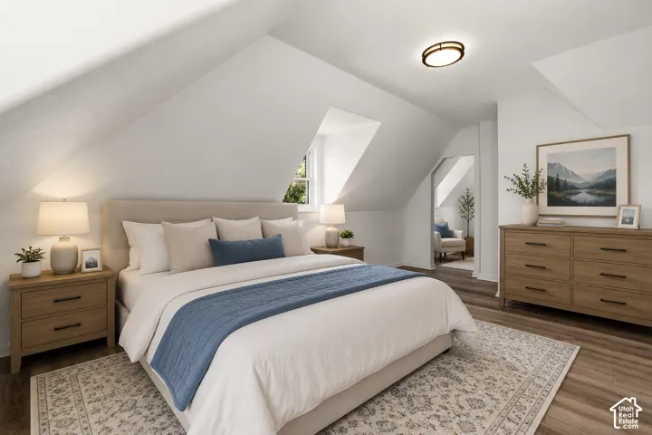 Room featuring sloped ceilings, wood-finish flooring, and a round flush-mount ceiling light
