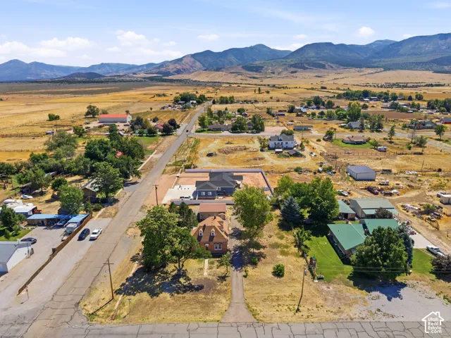 Expansive rural landscape featuring distant mountains and scattered residential properties