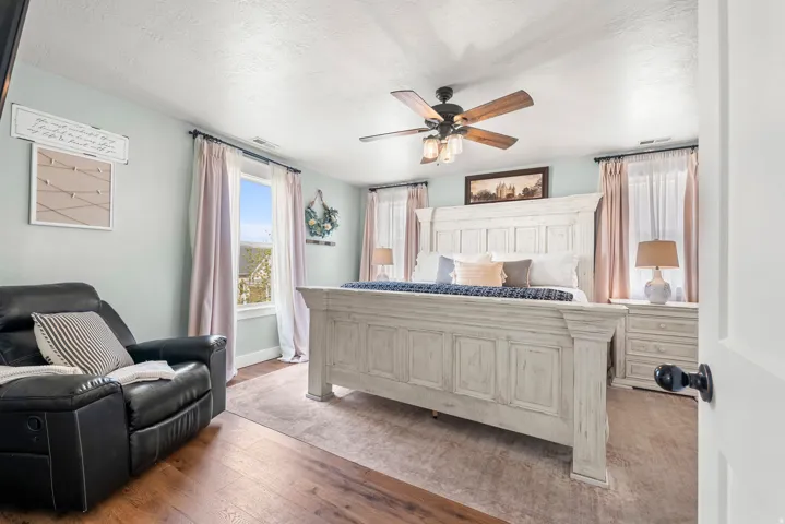 Bedroom featuring wood-type flooring, ceiling fan, and a textured ceiling