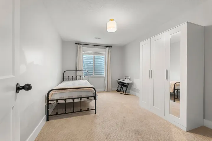 Bedroom featuring light carpet and baseboards
