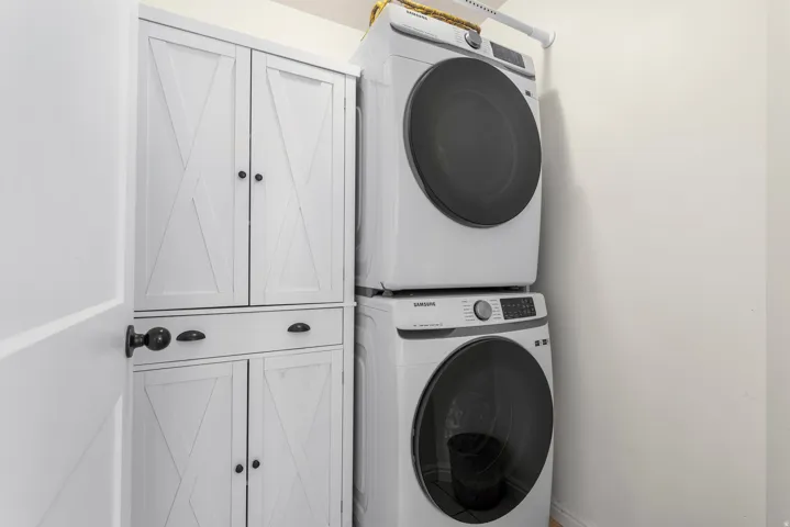 Laundry area with cabinet space and stacked washer / drying machine