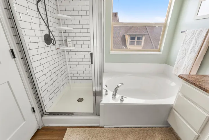 Bathroom with a bath, a shower stall, vanity, and dark wood finished floors