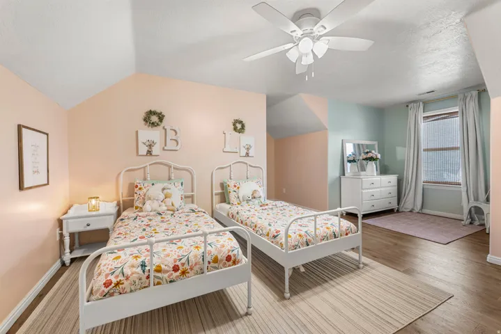 Bedroom featuring lofted ceiling, a ceiling fan, and light wood-style floors
