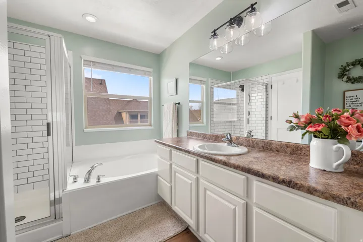 Full bath featuring a stall shower, vanity, a bath, and recessed lighting