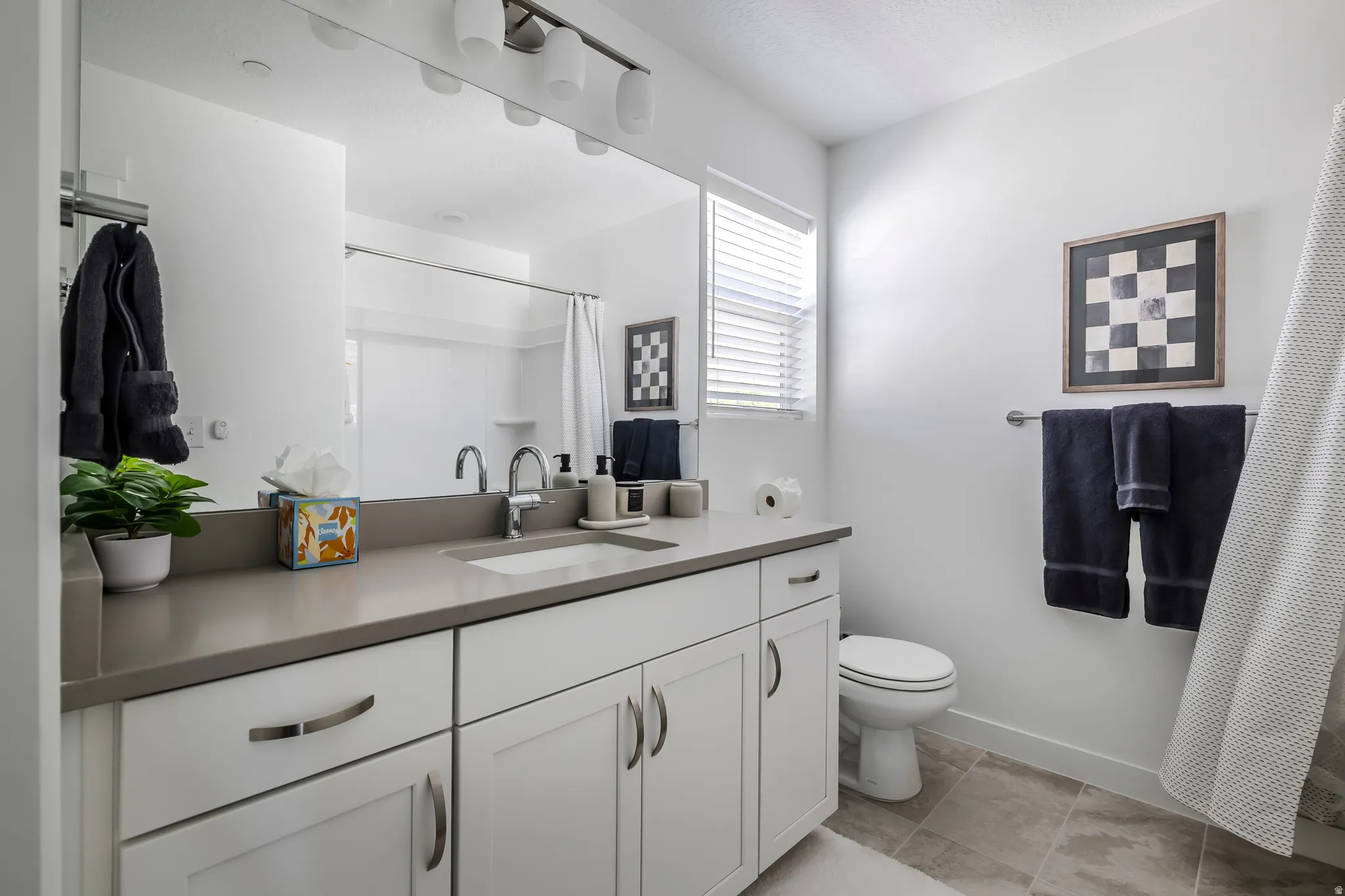 Bathroom with vanity, a shower with shower curtain, and light tile patterned floors