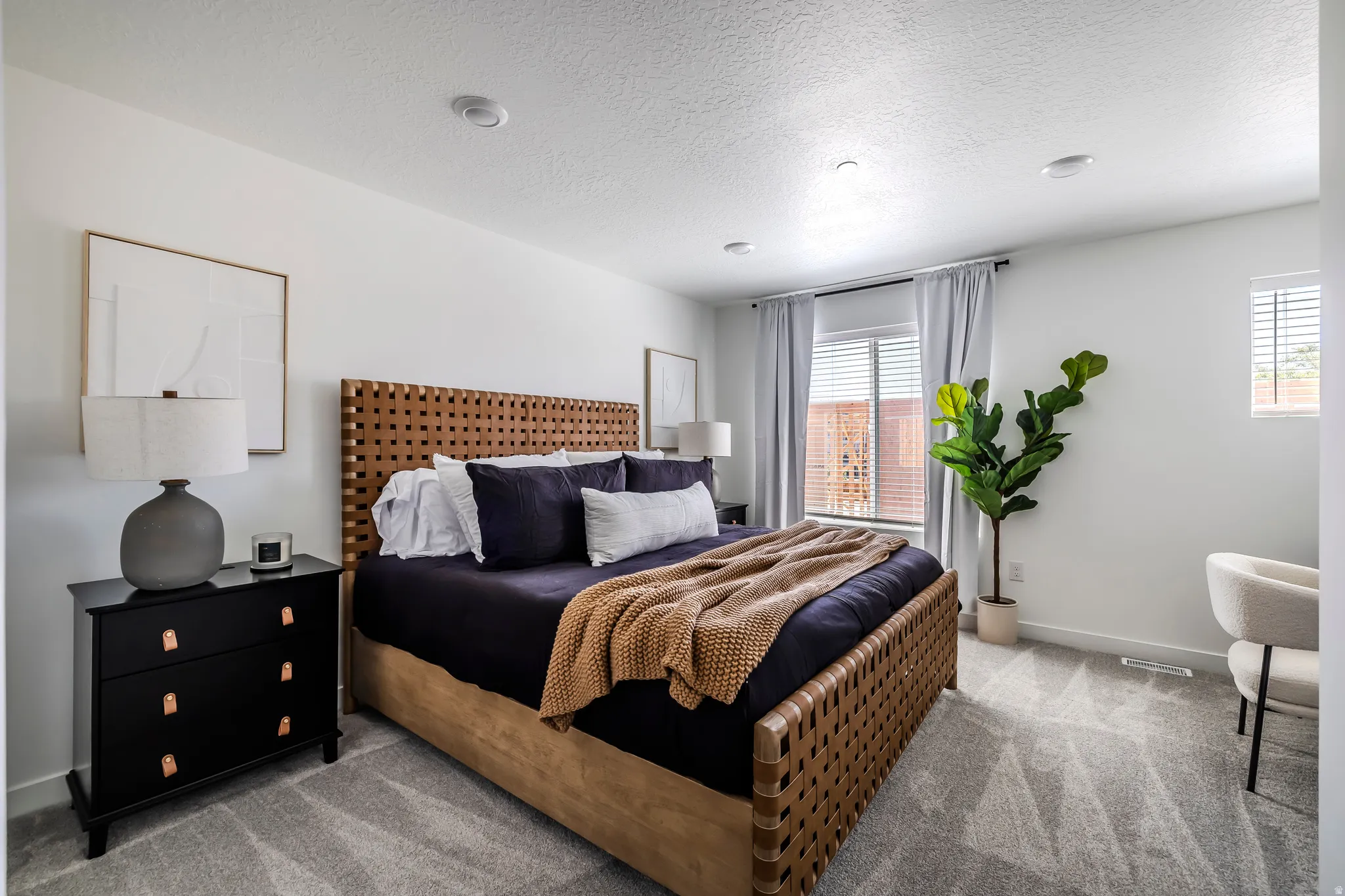 Bedroom featuring light colored carpet and a textured ceiling