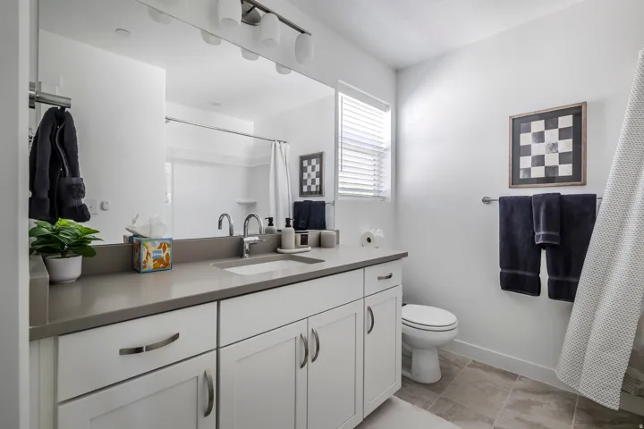 Bathroom with vanity, a shower with shower curtain, and light tile patterned floors