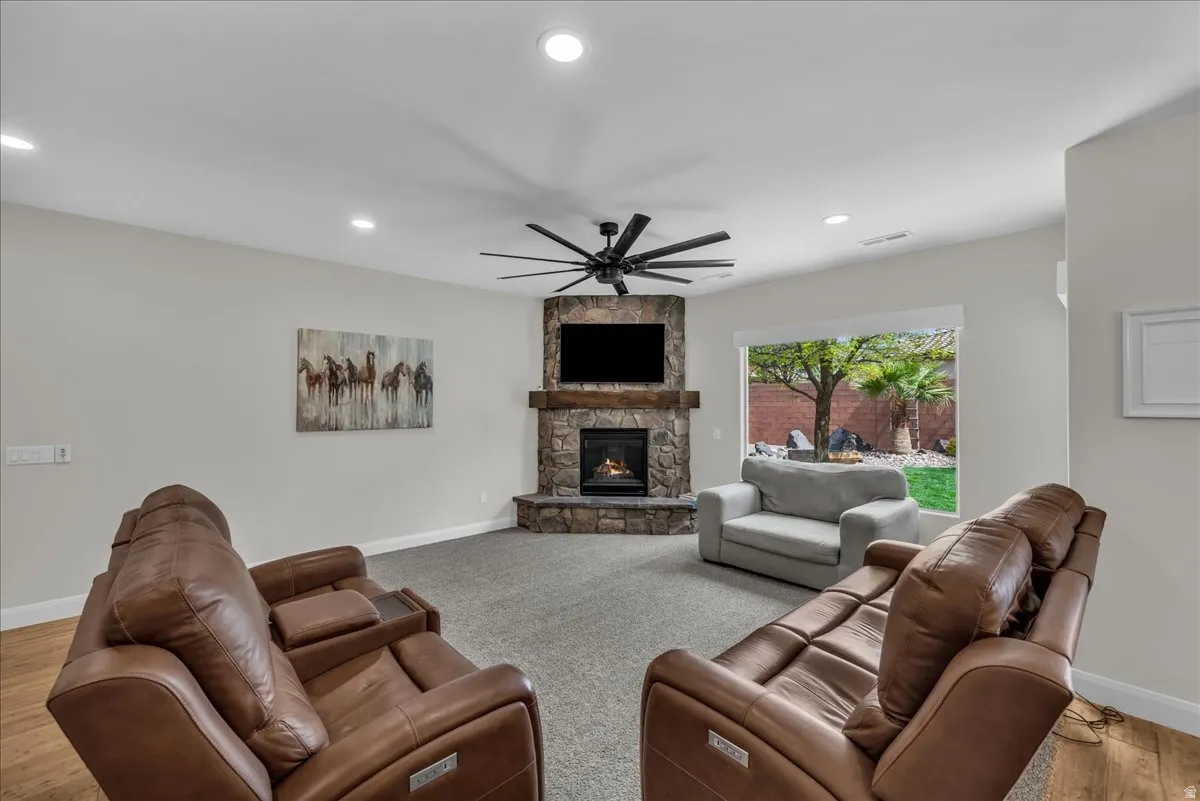 Living area with ceiling fan, a fireplace, recessed lighting, and light wood-style flooring