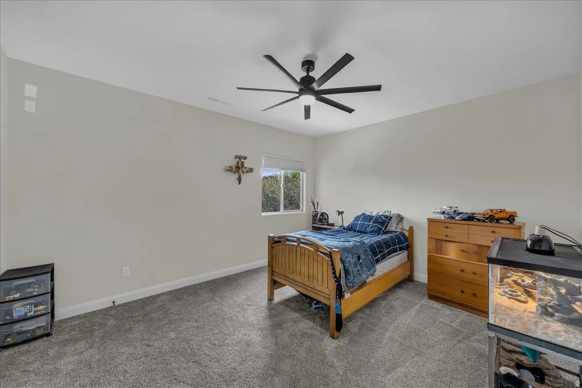 Bedroom featuring dark colored carpet and a ceiling fan