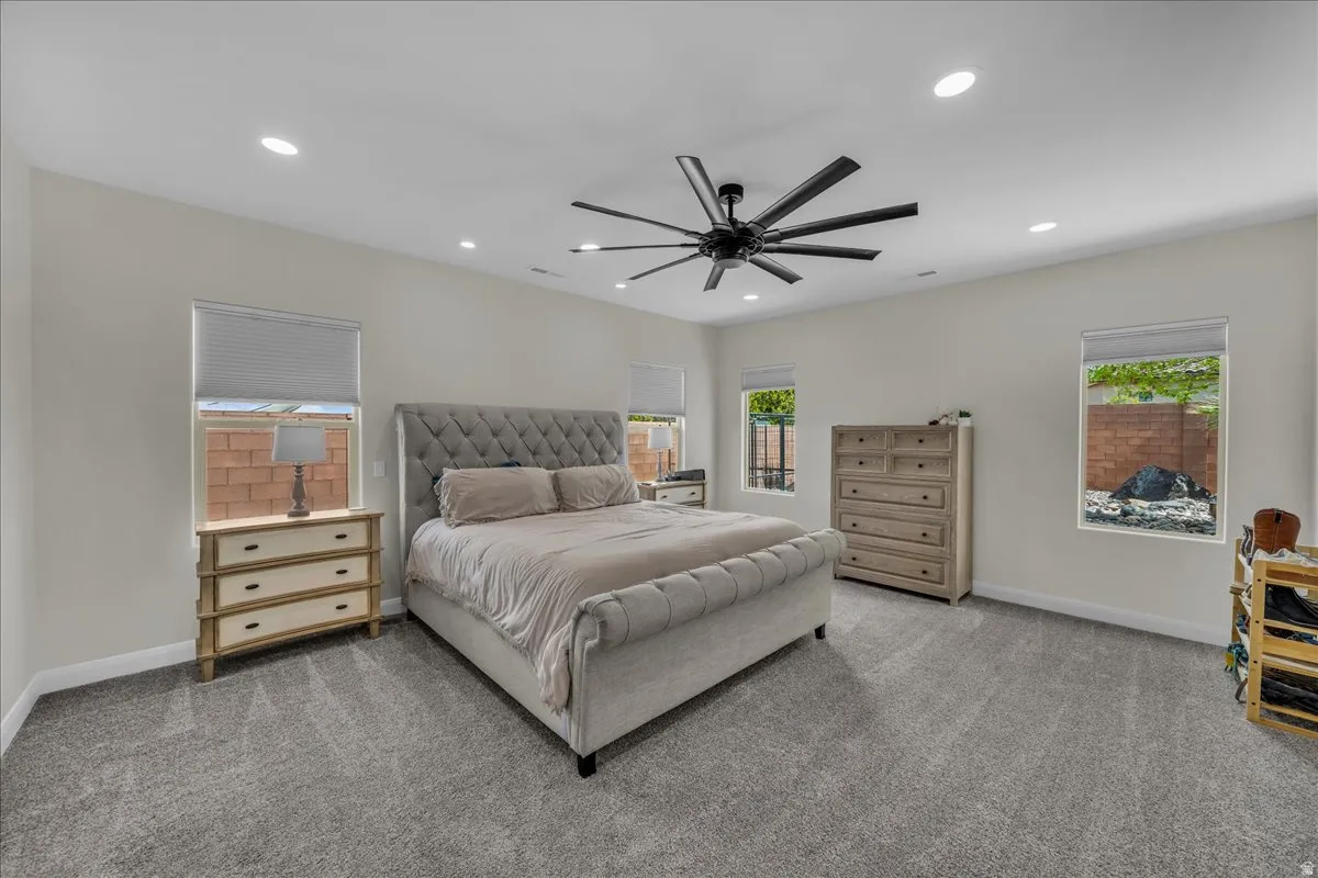 Bedroom with carpet, multiple windows, ceiling fan, and recessed lighting