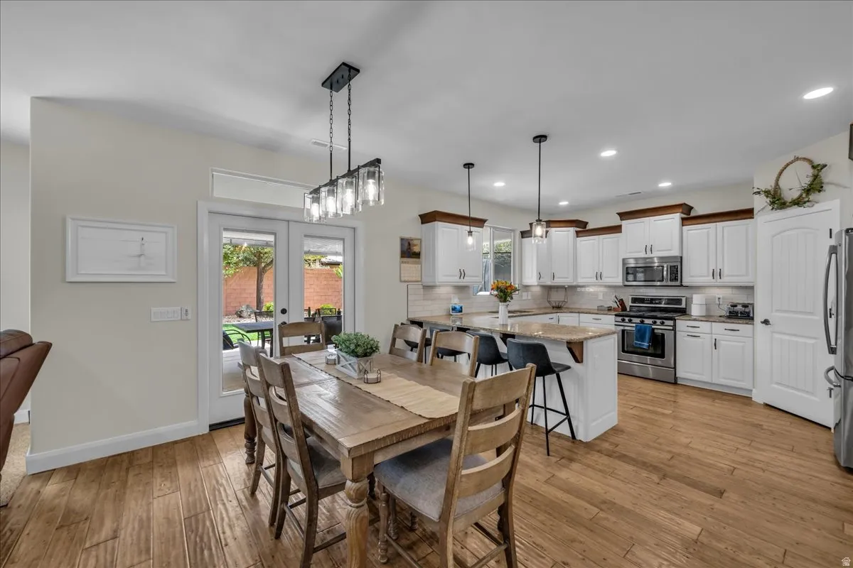 Dining space with french doors, light wood-type flooring, and recessed lighting