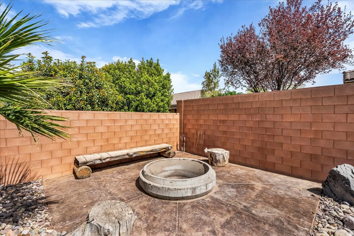 Fenced backyard with an outdoor fire pit and a patio