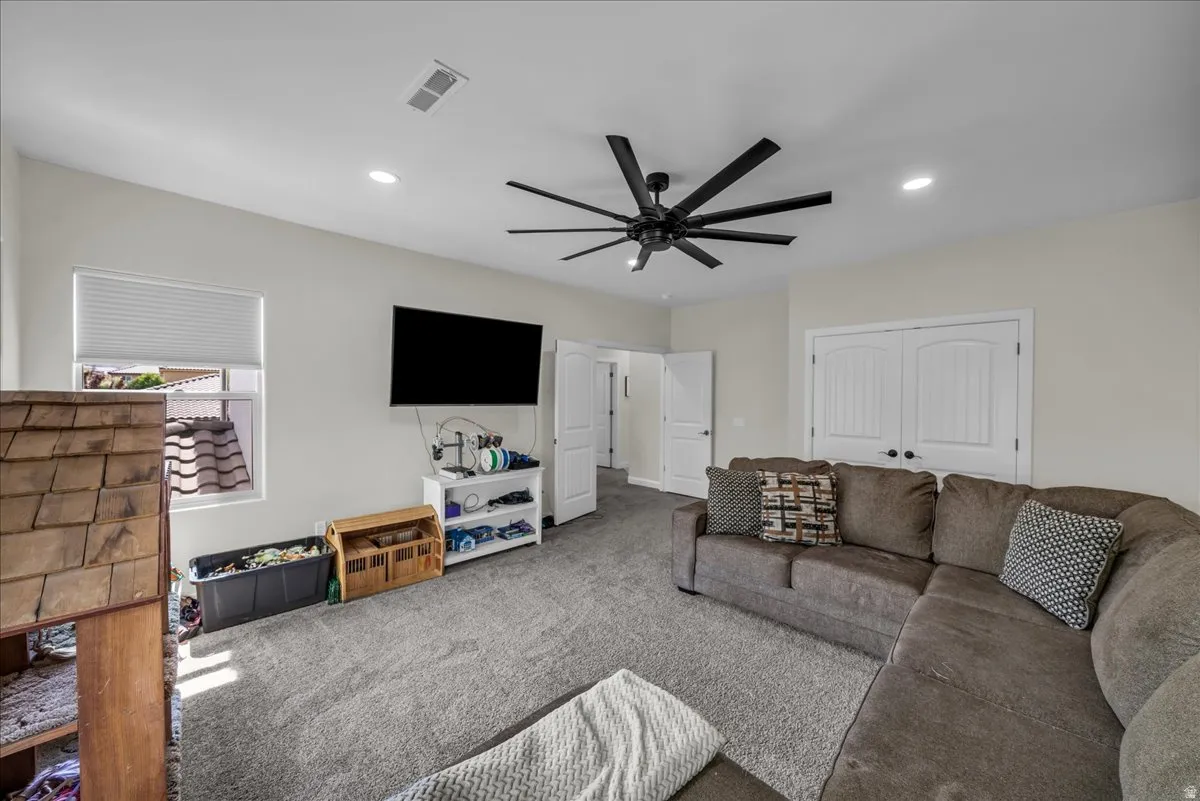 Living room featuring carpet floors, a ceiling fan, and recessed lighting